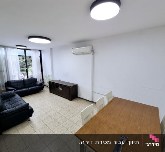 סלון עם ספות שחורות ושולחן עץ